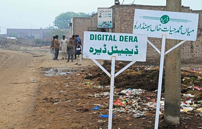 In this picture taken on January 7, 2022, villagers stand next to the Digital Dera office in Chak Twenty-six SP. — AFP